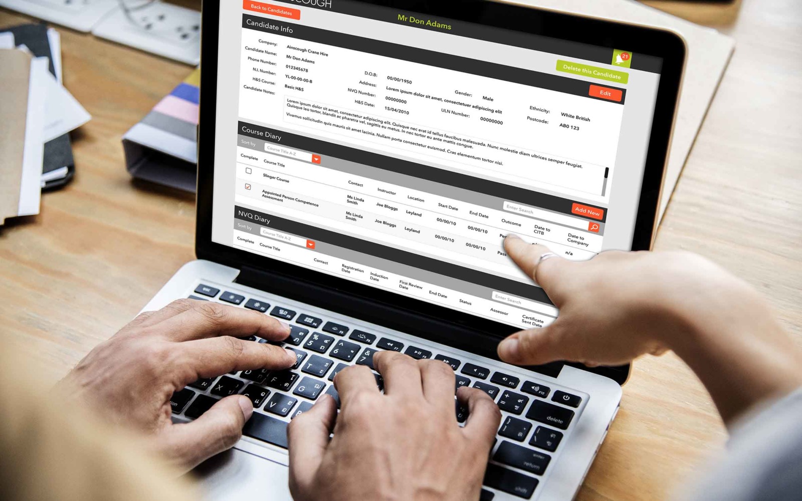 Two people using a computer displaying Ainscough Training Services' training CRM and workflow management software