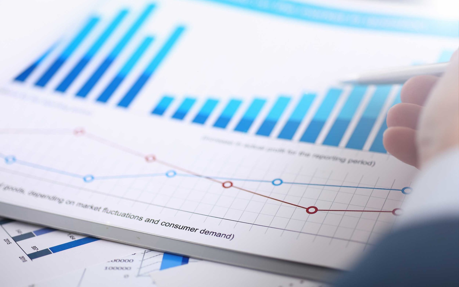 Pen pointing to a positively increasing chart representing an improvement in productivity and profitability